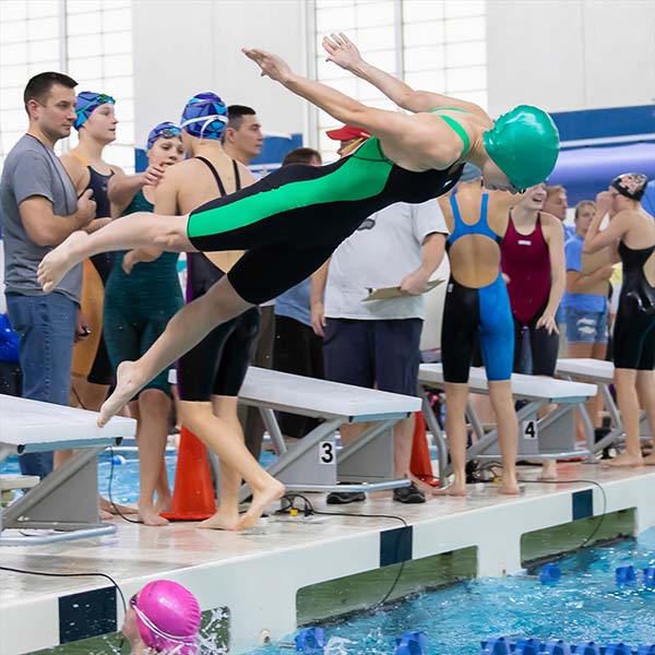 A swimmer launching from a board