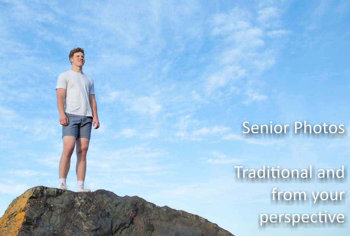Senior standing on a rock with open sky