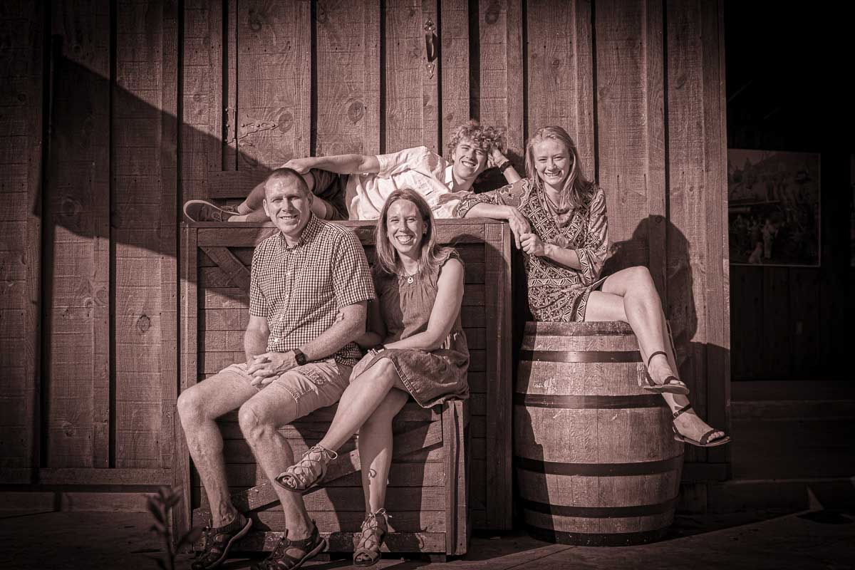 Western-styled picture of family with wooden backdrop